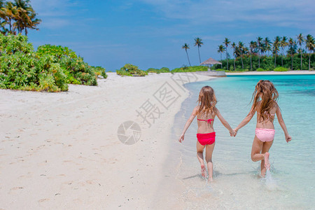 可爱的小孩在白沙滩上玩得开心在浅图片