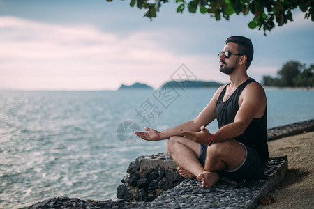 年轻人在海边做瑜伽一个帅哥日落图片