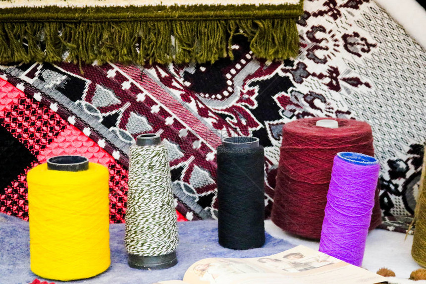 多彩亮丽的纱线人造丙烯酸纤维线缝纫线卷轴在亮色织物的背景下制作衣图片