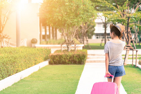 旅行大粉红袋或行李在花园公行走并准备旅图片