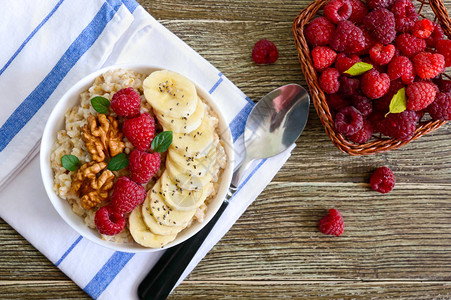 美味健康的燕麦片配香蕉覆盆子坚果健康的早餐健身食品适当的营养图片