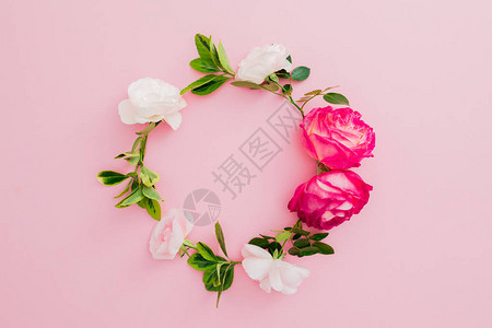 白玫瑰红玫瑰花和粉红色背景的叶子环形壁平躺着图片