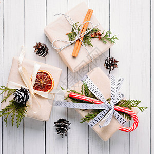 带松果和肉桂棍的礼品盒白色背景圣诞装图片