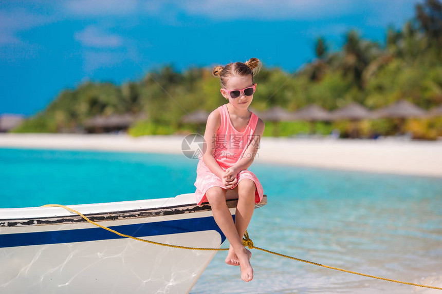 快乐的小女孩在沙滩上渡暑假图片