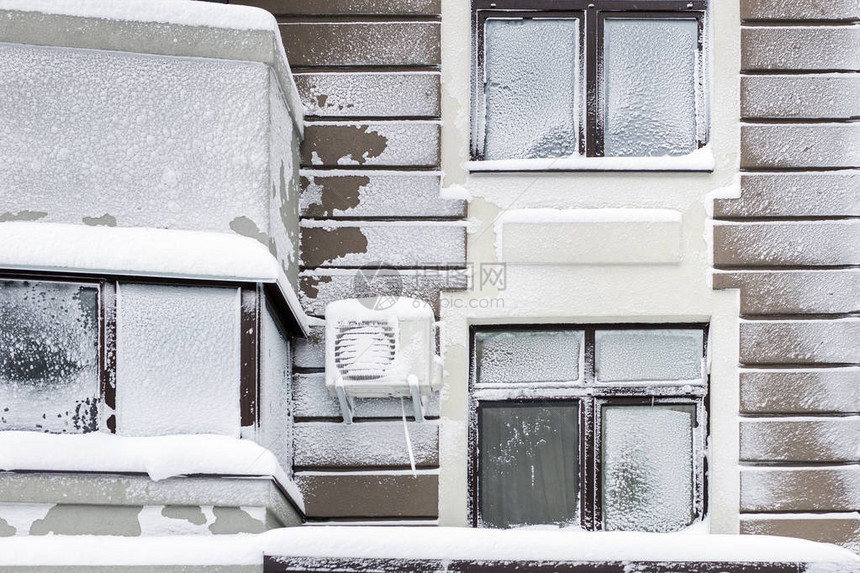 现代高层公寓的建筑立面在雪暴和冬季暴风雪后覆盖着雪和霜寒冷多图片