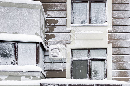 现代高层公寓的建筑立面在雪暴和冬季暴风雪后覆盖着雪和霜寒冷多图片