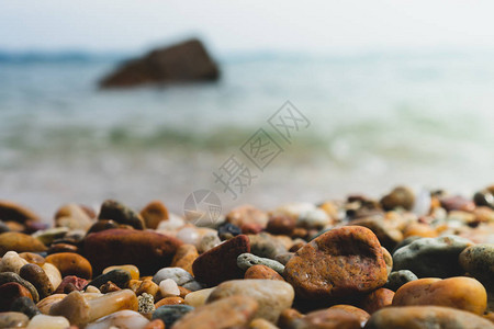 选择地关注显示产品背景中模糊海滩的岩石纹理图片