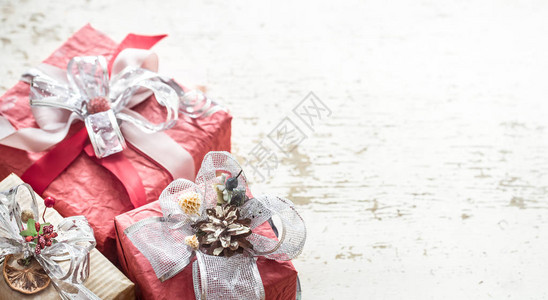 在浅色木质背景上带有蝴蝶结的节日精美礼品盒图片