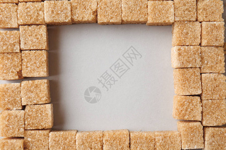 浅色背景中由棕色甘蔗糖块制成的正方形图片