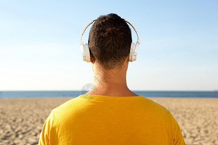 在海滩用耳机监听音乐的人图片