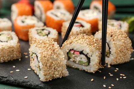 用筷子吃美味的寿司特写图片