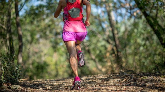 在森林小径上奔跑的年轻女子图片