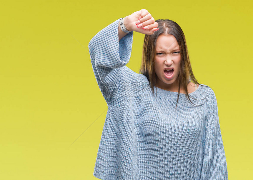 年轻漂亮的白种女人穿着冬季毛衣在孤立的背景下愤怒而疯狂地举起拳头沮丧和愤怒图片