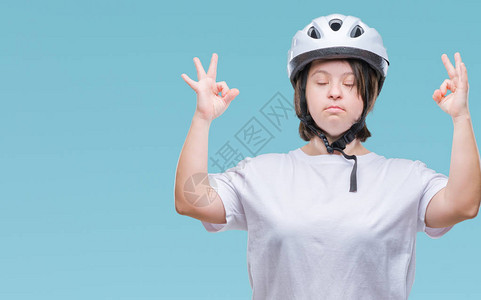 患有唐氏综合症的年轻成年骑自行车者在与世隔绝的背景下戴着安全帽放松图片