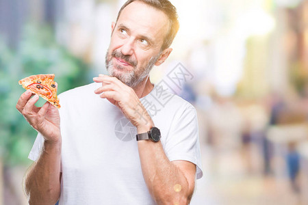 中年白发老人在孤立的背景下吃披萨片图片