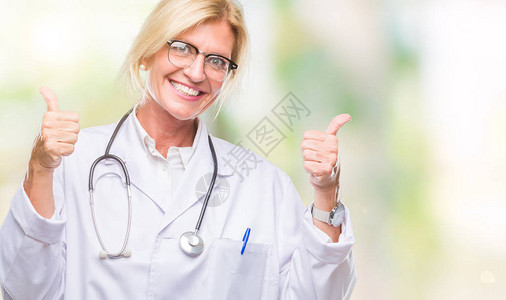 中年金发女医生在孤立的背景成功标志上用手做积极的手势图片