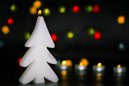 圣诞蜡烛在多彩的灯光上烧着图片