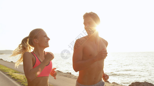 运动的女人和男人在有趣的海洋慢跑过程中看着对方的眼睛图片