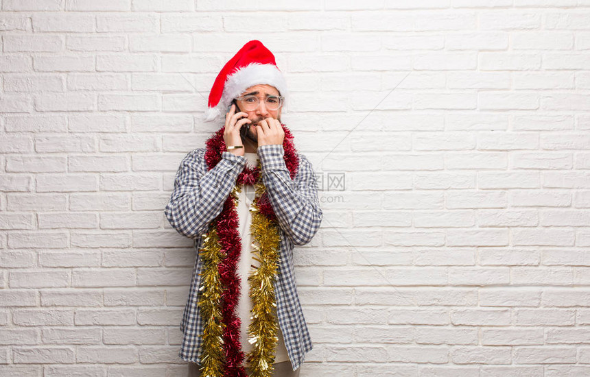 年轻人坐着礼物庆祝圣诞节咬指甲紧图片