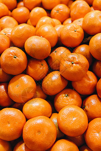 一堆新鲜的橘子食物背景图片