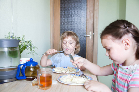 小女孩坐在厨房吃煎图片