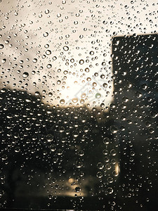 玻璃上的雨滴和太阳光线的美丽图像图片