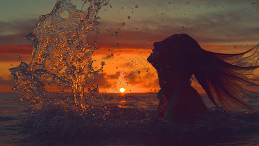 未知的女人用头发在壮观的橙色夕阳上喷洒玻璃般的海水图片