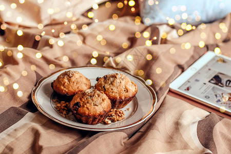 圣诞节早上有美味新鲜的胡桃松饼和床图片