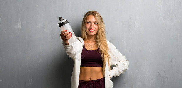拿着一瓶水的年轻运动女图片