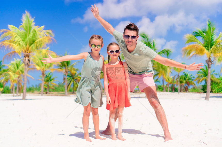 父亲和快乐的小女孩们在棕榈林白沙图片