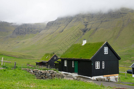 在广阔的绿色山谷中拍摄了一个传统的斯堪的纳维亚村庄的风景图片