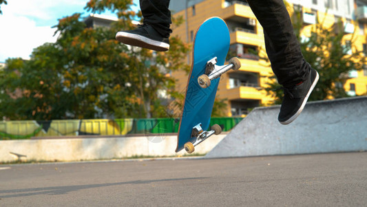 滑板上无法辨认的人在城市公园做了一个很酷的翻转动作图片