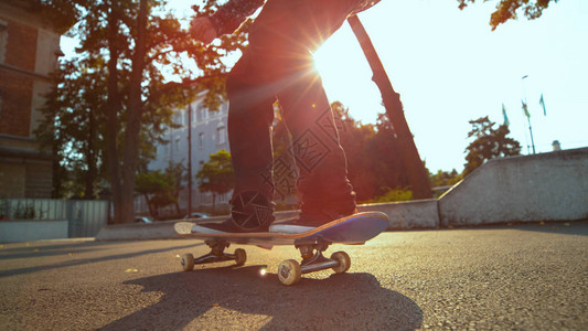 不知名的滑板手在城市小镇阳光明媚的街图片