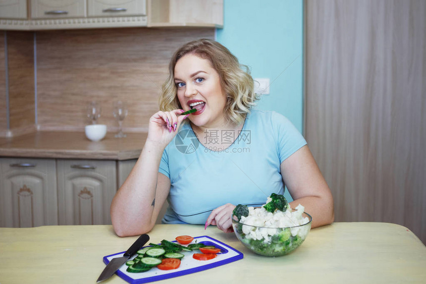 年轻漂亮胖金发女人吃绿色黄瓜和西兰花健康饮食饮食对图片