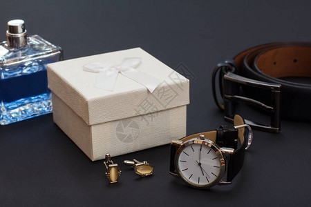 男士科隆香水白色礼品盒袖扣黑色皮带手表和黑色背景金属扣皮图片