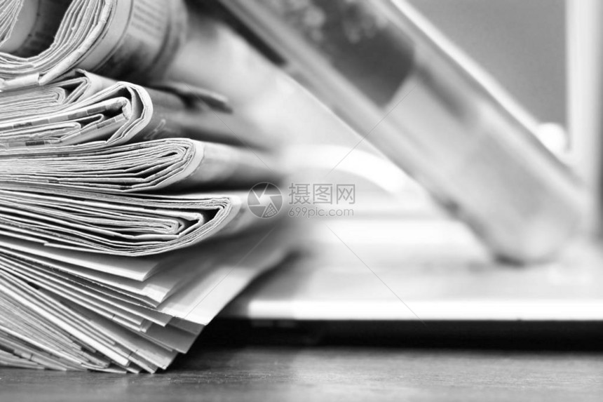 一堆新鲜的早报放在办公室的笔记本电脑上日报中的最新金融和商业新闻包含信息图片