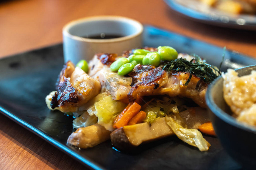 在黑板上用杯酱汁鸡排的特写餐厅里的青豆和日本海藻配胡萝卜图片