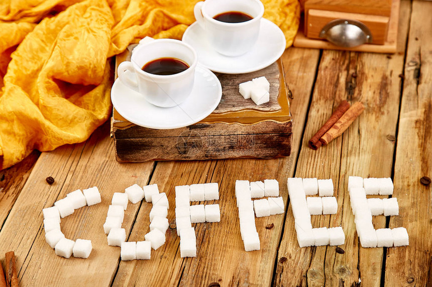 象征形象方糖的文本签署咖啡仿古木桌上的糖块附近的两杯咖啡浓缩咖啡图片