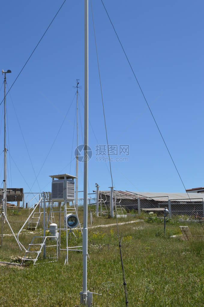 山顶的气象站与蓝天和草地对峙在一个阳光夏图片