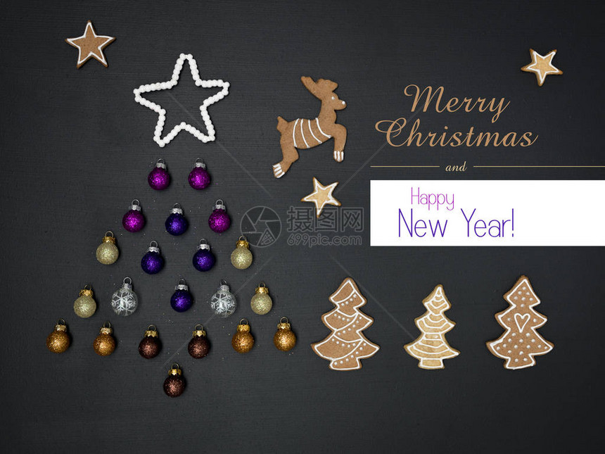 黑色板背景上用圣诞装饰品制成的问候字母和树图片