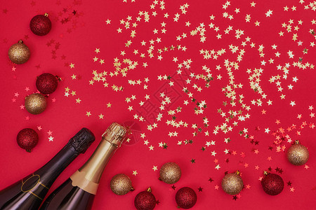 两个香槟瓶与红色背景上的圣诞装饰品圣诞节周年纪念新年庆图片