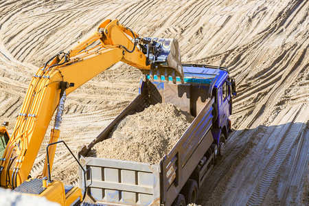 挖土机和卡车在采砂场的工作挖掘机将沙图片
