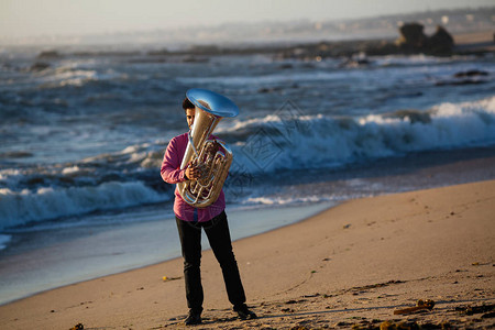 年轻的音乐家在海边演奏大号图片