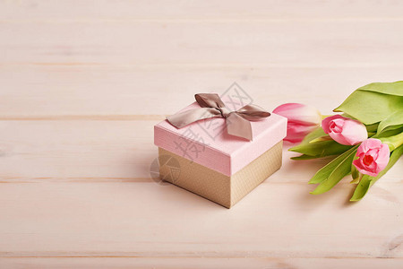 浅色背景中带鲜花的粉色礼盒背景图片