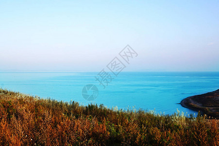 在高山的海全景背上的野草场绿松石海和它上面柔和的紫色天空俄罗斯东部图片