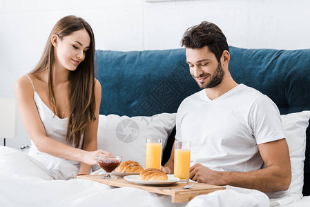 年轻夫妇坐在床上早图片