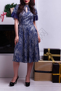 时尚美丽优雅的年轻黑发女人穿着漂亮的蓝色连衣裙摆在上的照片图片