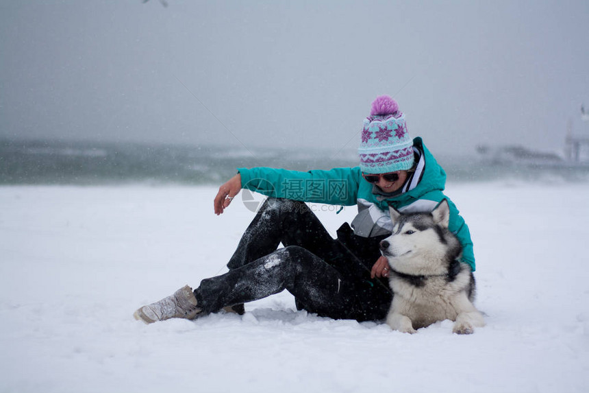 年轻女人在海边滩的雪上玩得开图片