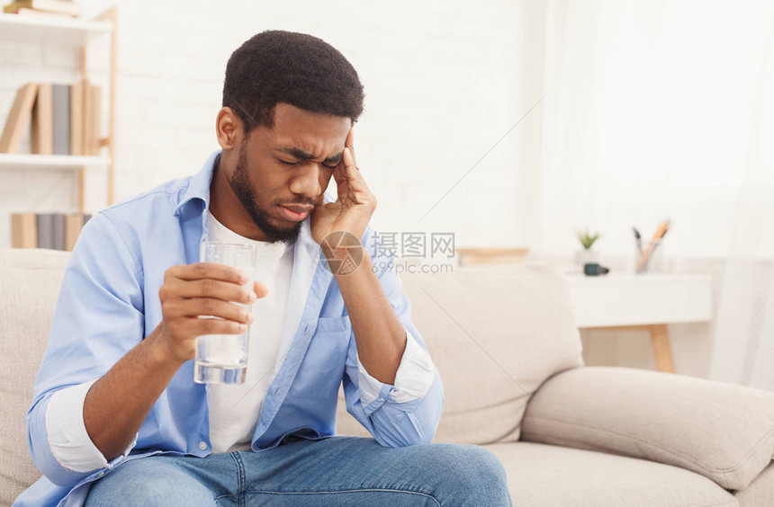 生病的非洲美国人服用药丸和水杯图片
