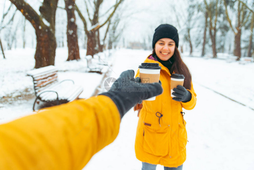 女人给朋友喝咖啡在雪地冬图片